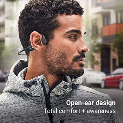 a man wearing the AfterShokz Aeropex AS800 headphone to demonstrate the open-ear design, with its awareness and comfort