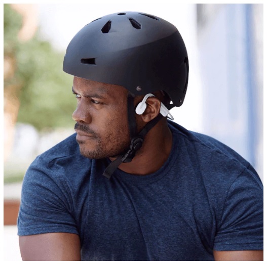 a man on a bicycle, wearing a cycling helmet and listening to music with the shokz openmove bone conduction headset