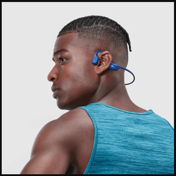 Close-up view of wireless bone conduction headphones properly placed on cheekbones for optimal sound transmission.