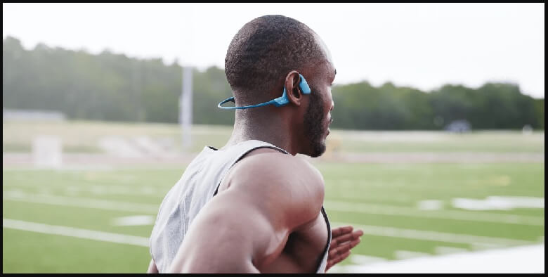 active person wearing bone conduction headphones with Bluetooth - runner enjoying music with bone conduction headphones