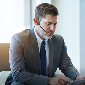 a business man going through his daily routine of following up with work progress the day before through phone calls to managers at the office, from the vidonn f3 headset