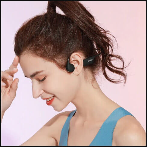 Close-up view of bone conduction headphones worn by a person, showcasing their unique design.``
